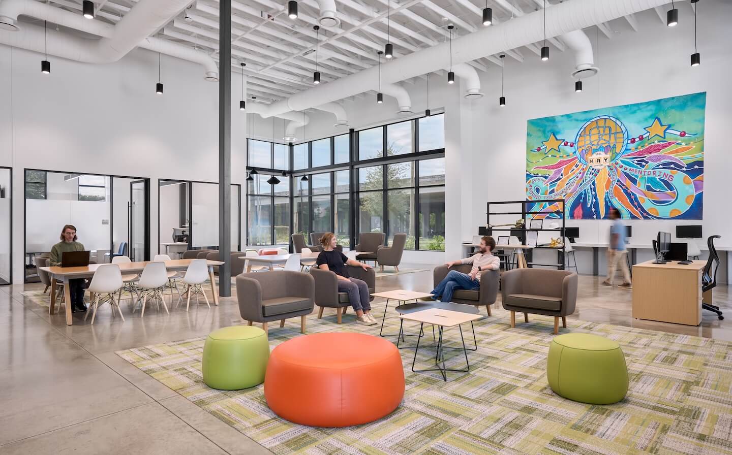 Shared lounging and working space in The HAY Center features colorful artwork and design elements to promote community building.
