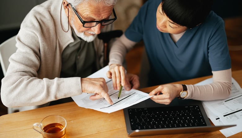 A nurse and patient going over medical documents.