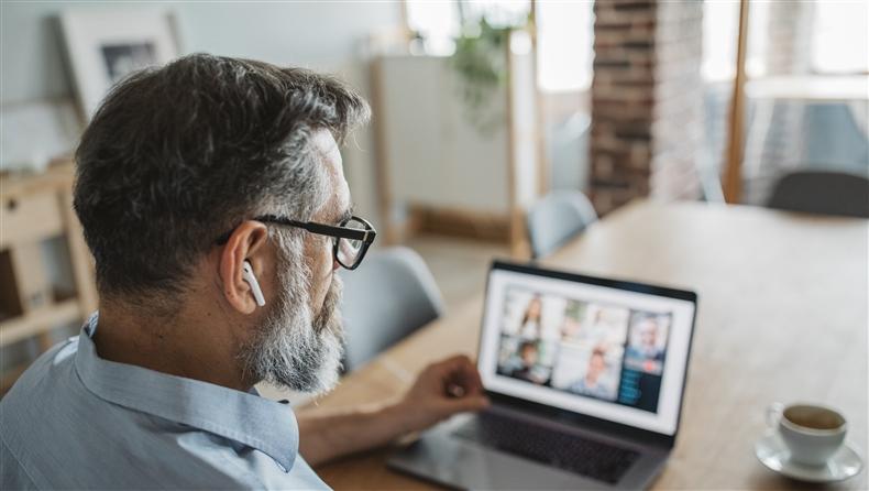 Man with earpods on laptop