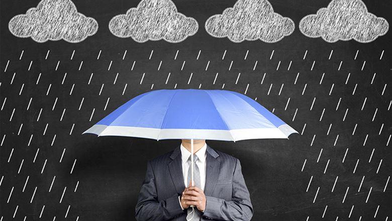 a man holding an umbrella with clouds of rain above him