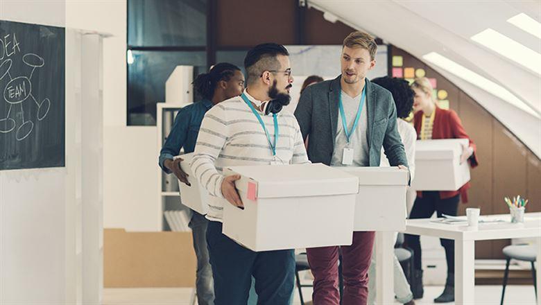 group of young professionals moving boxes