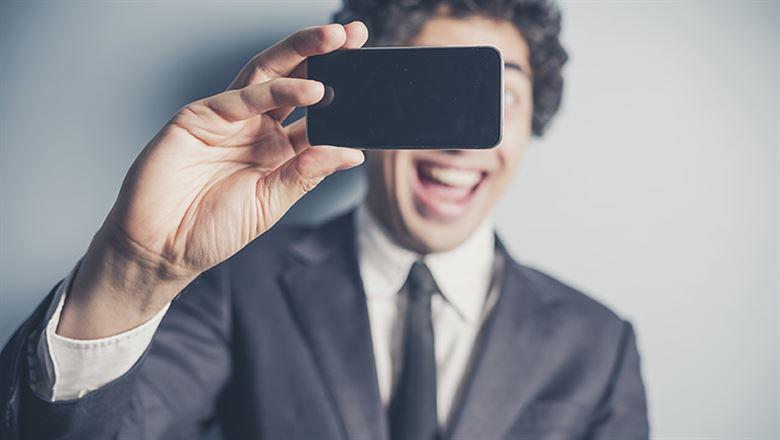 young professional with a big smile taking a selfie