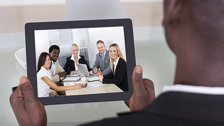 a businessman viewing a webinar on his tablet
