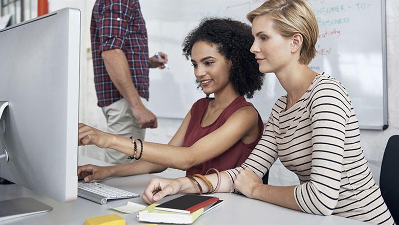 two female designers working on a computer