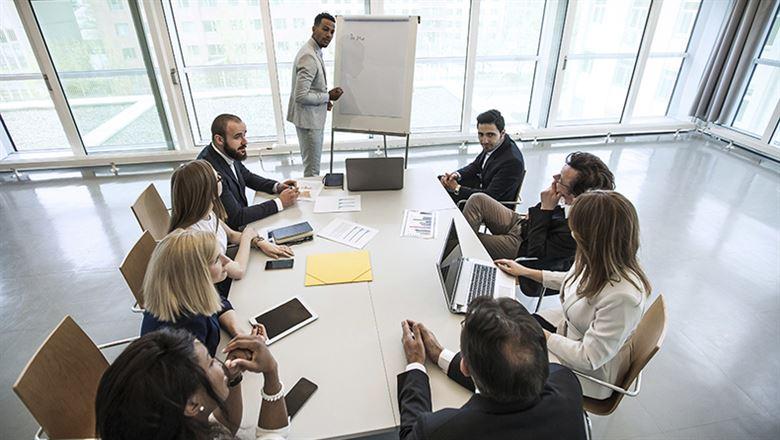 a businessman presenting to a room of colleagues in a meeting