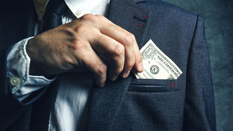 a hand slipping a dollar bill out of a suit jacket pocket 