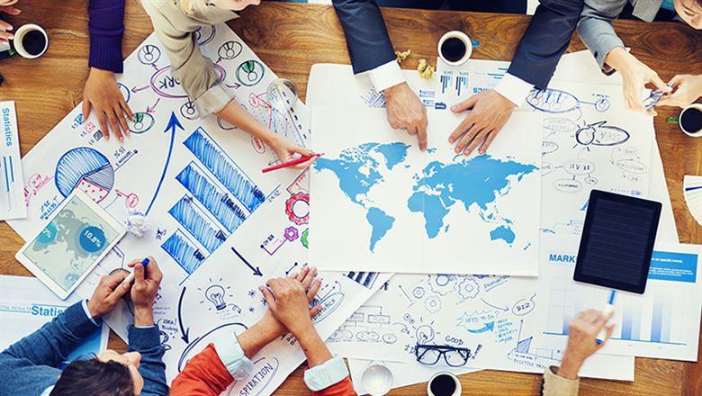 hands of diverse professionals touching global maps and charts