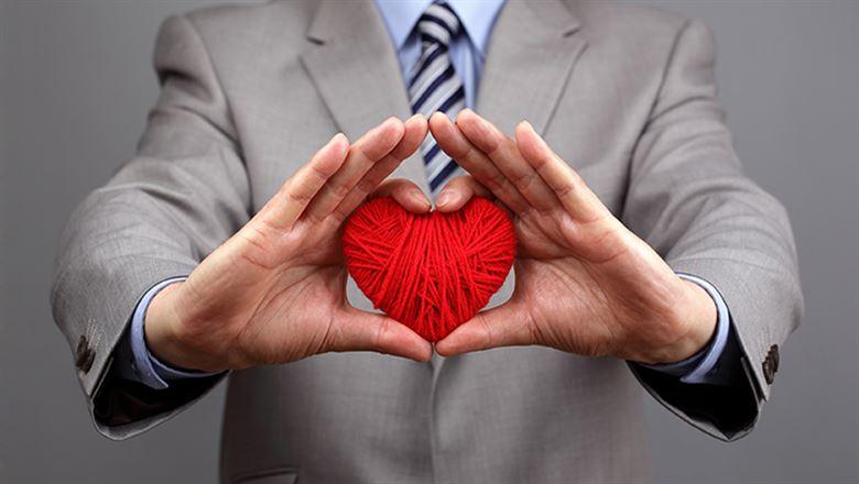 person holding a red woolen heart