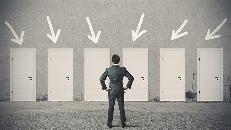 businessman looking at doors with arrows above them