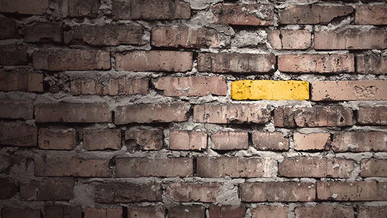 a yellow brick standing out from other bricks on a wall