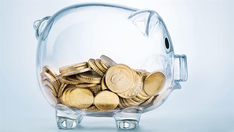 gold coins in a see-through piggy bank