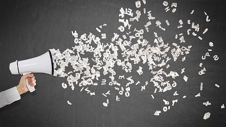 a hand holding a loud speaker with letters flying out of it