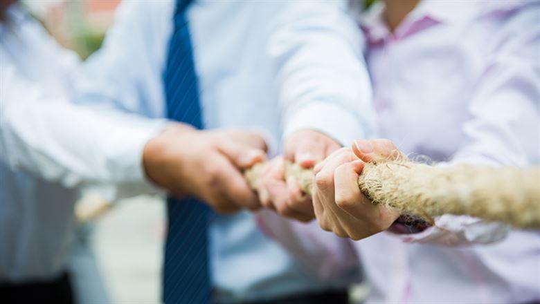 business professionals in tug of war