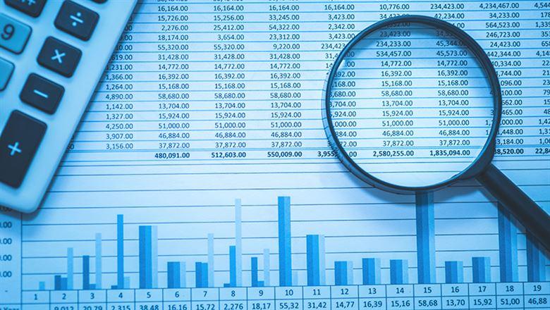 financial spreadsheet and magnifying glass