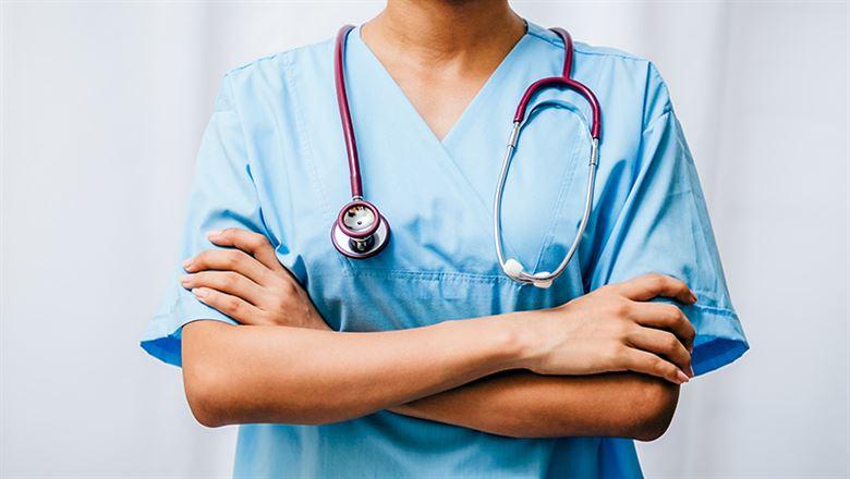 a close-up of a stethoscope on a medical professional in blue scrubs