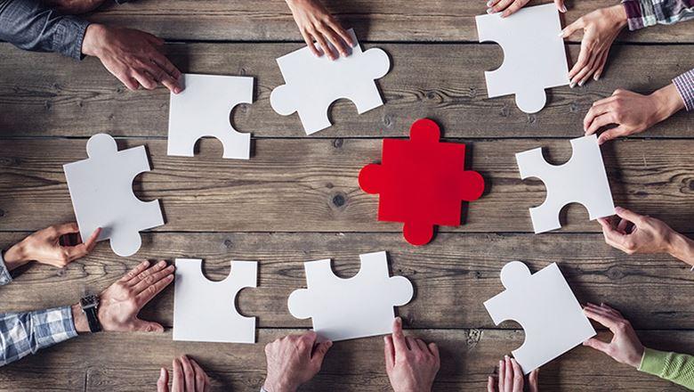 group of people holding puzzle pieces