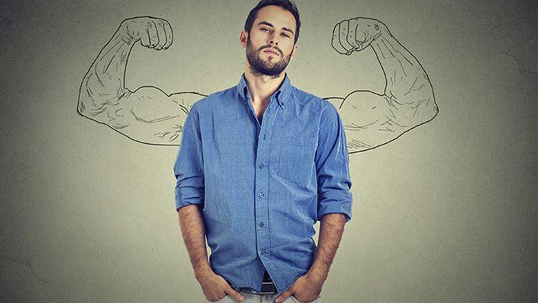 man standing confidently with muscle arms drawn behind him