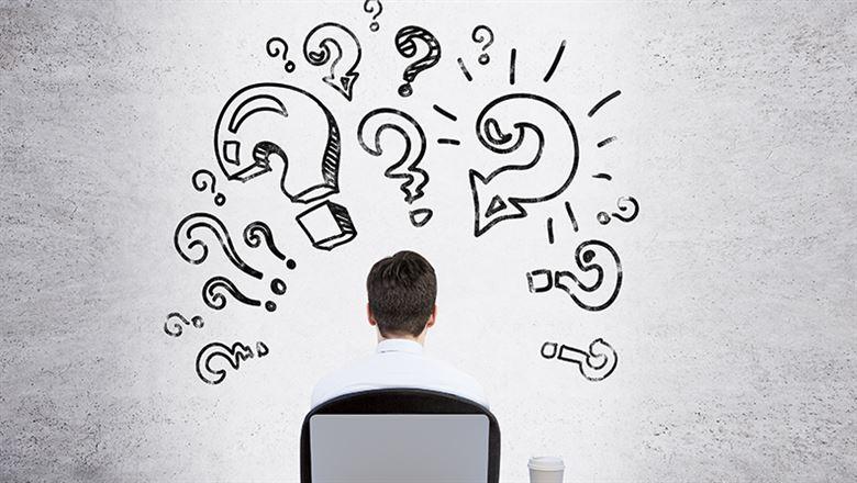 businessman with animated question marks drawn above his head