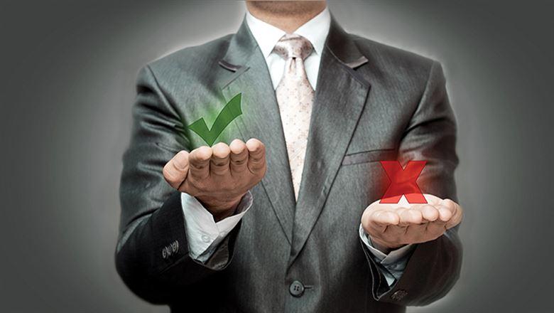 a businessman holding a green check in one hand and a red x in the other