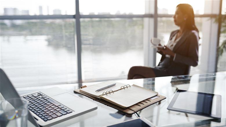 woman sitting in her work office with her desk as the focal point