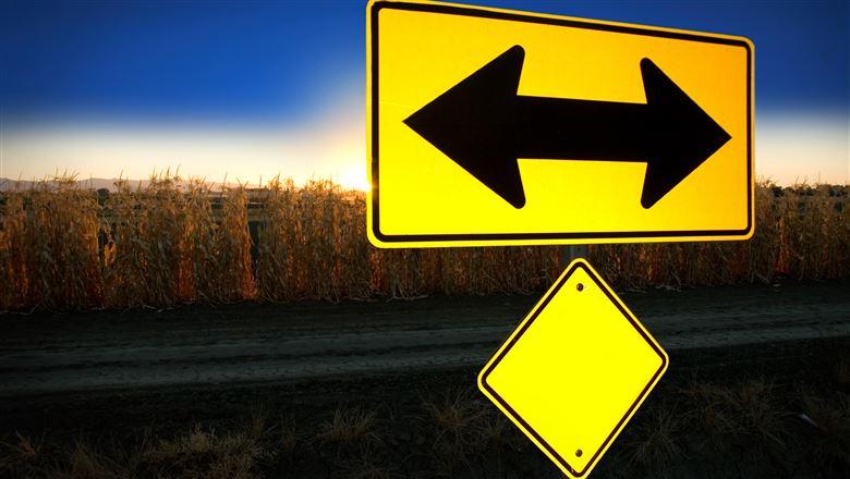 a yellow road sign with double arrows