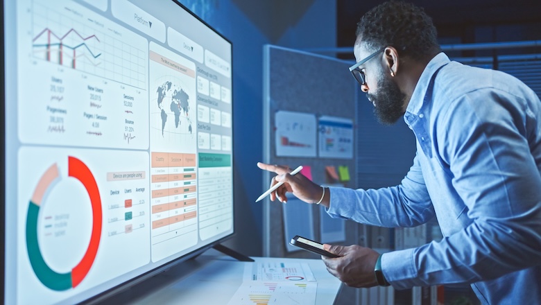 A man looking at analytics data on a screen