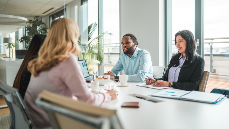 Employees sitting at a table in a meeting