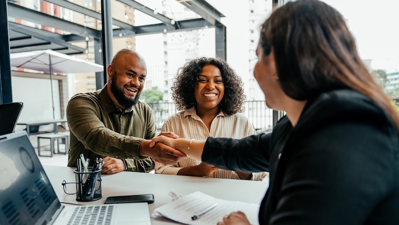 Couple closing real estate contract with real estate agent