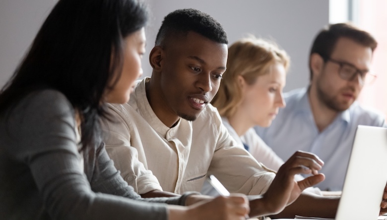 Coworkers working at a laptop together