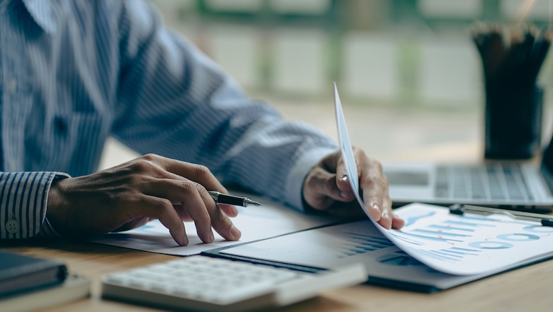 Young Asian businessman hand pressing a calculator to calculate