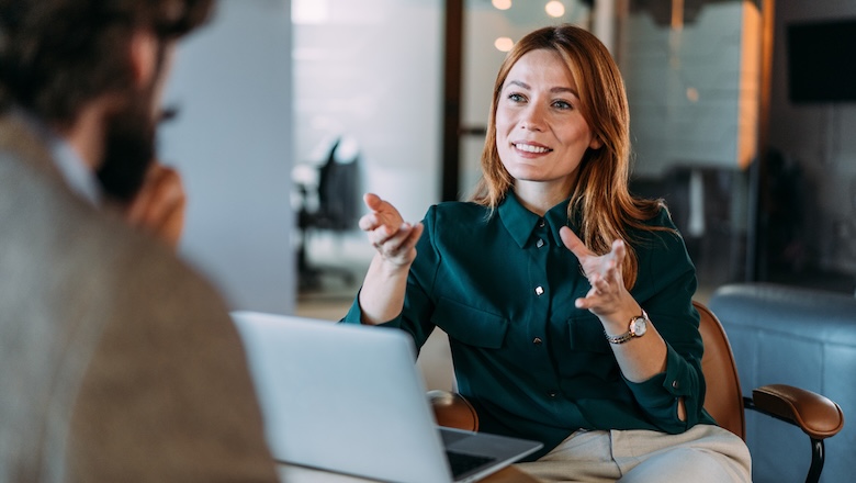 Shot of two colleagues having a discussion in the office. Creative business persons discussing new project and sharing ideas in the workplace.